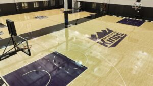 Overhead view of an empty basketball court with Stockton Kings branding on the floor and purple key areas.